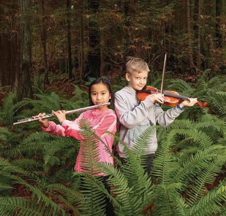 Children playing music in the forest